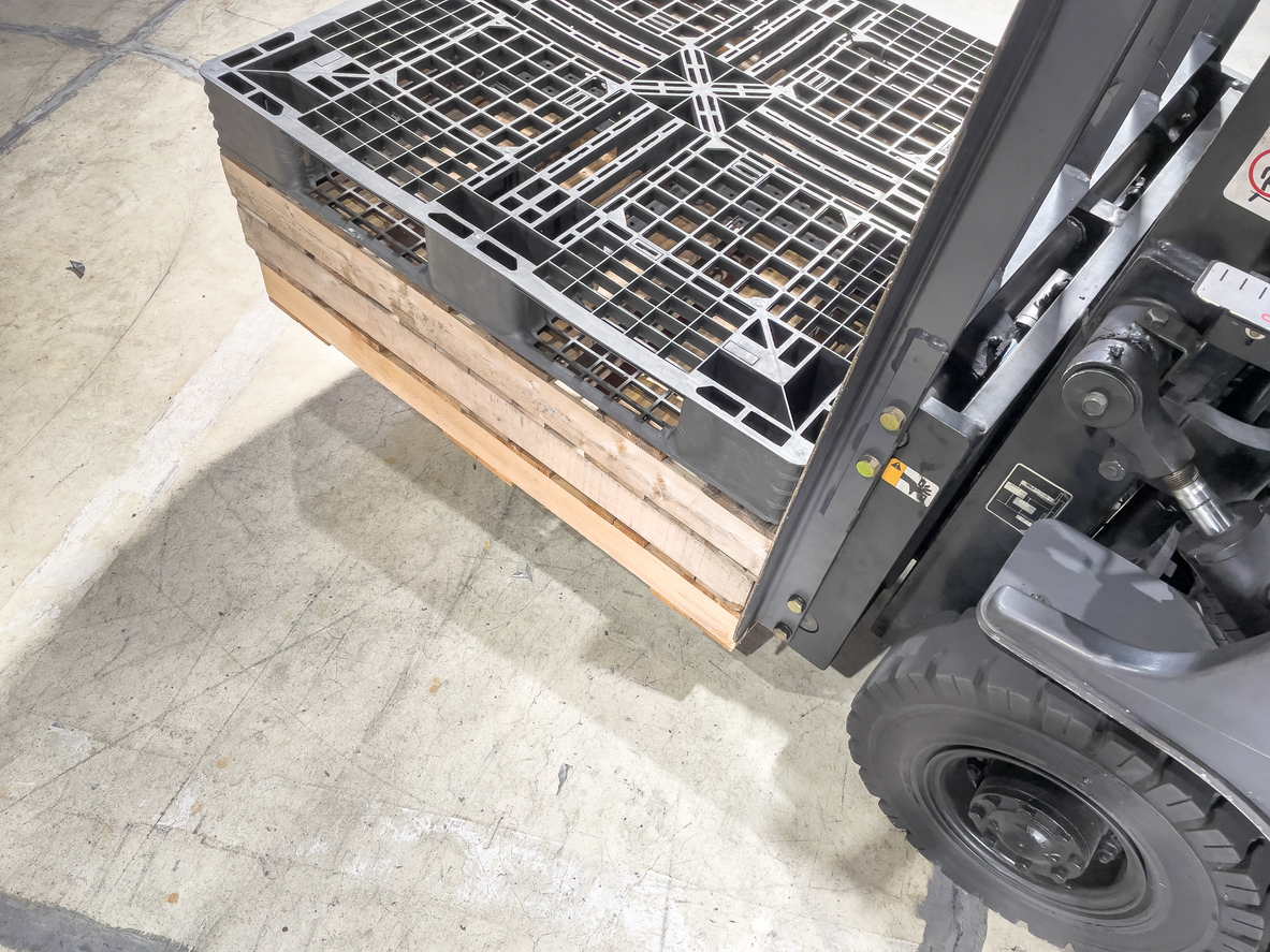 A forklift carrying an empty pallet